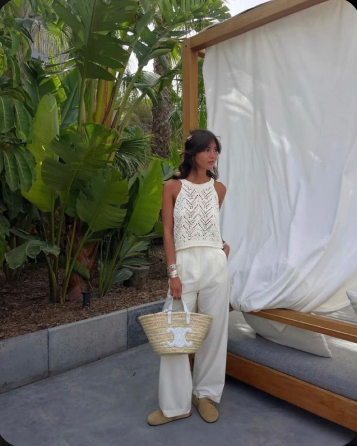 White crochet top and loose pants with a LOEWE straw bag